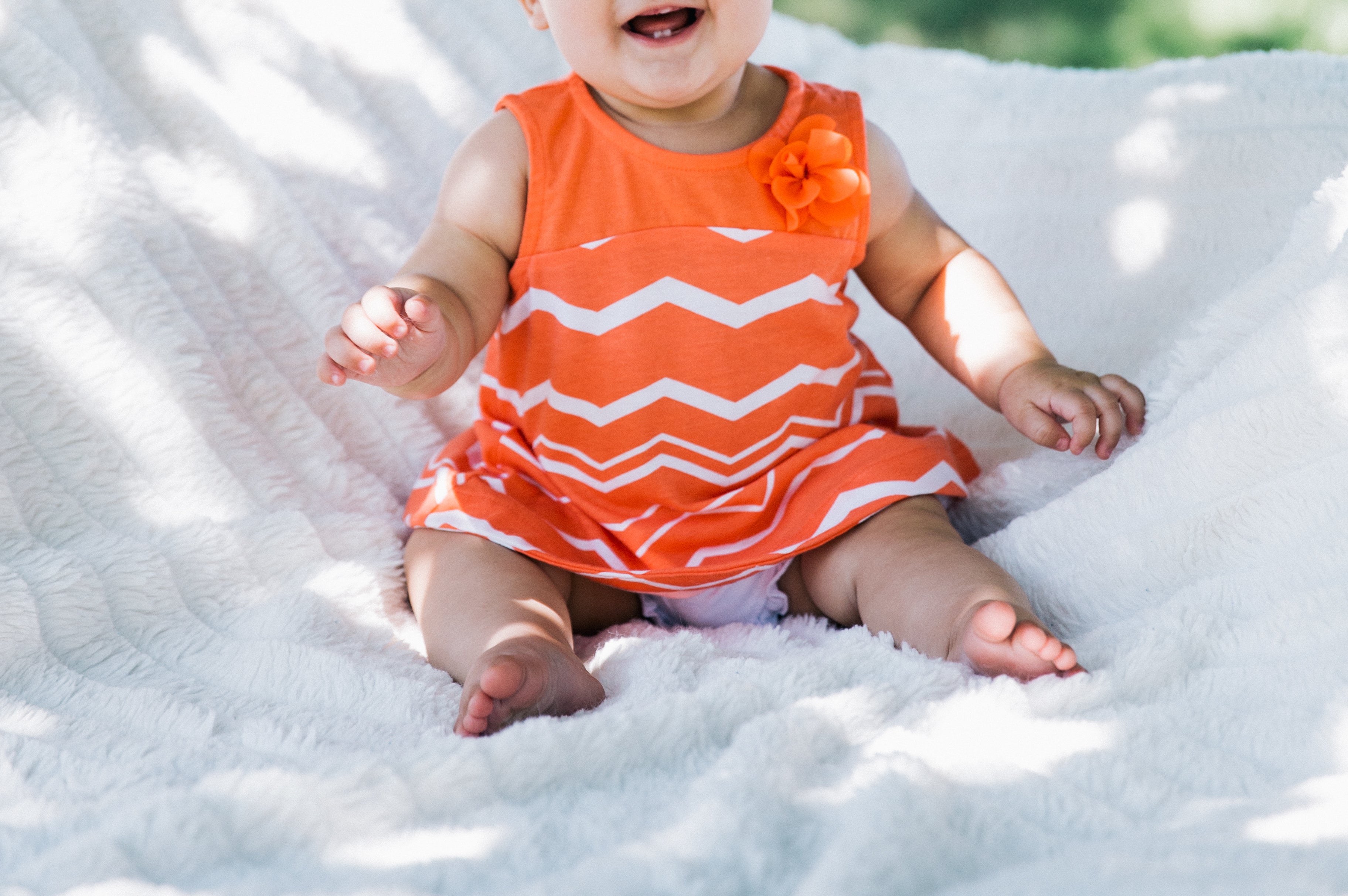 baby girl in orange dress feet